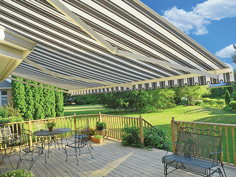 A Sunesta awning extends out over a home patio in the Northeast