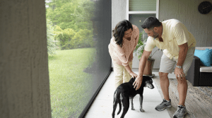couple petting dog in comfort of shade from patio screen